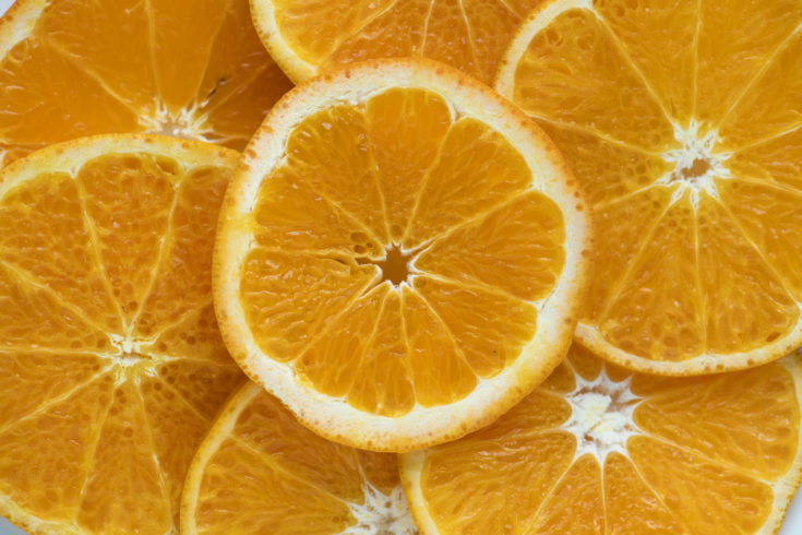 Closeup of sliced juicy oranges textured background