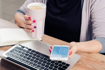 Woman Checking Phone & Drinking Coffee While Checking Email